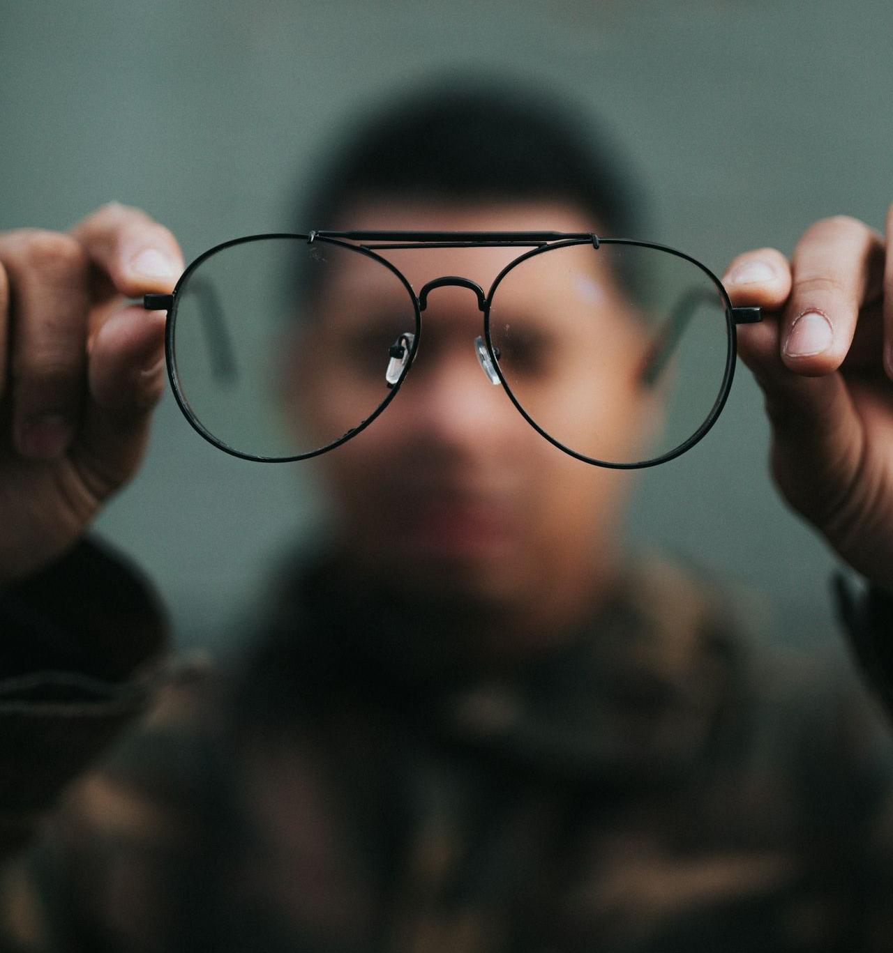 man holding eyeglasses